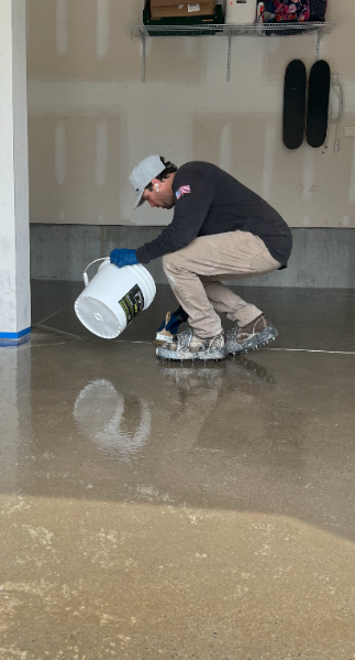 Surface Shield technician applying a concrete coating with spiked shoes