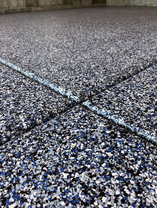 Close-up of blue, white, and black flake epoxy garage floor