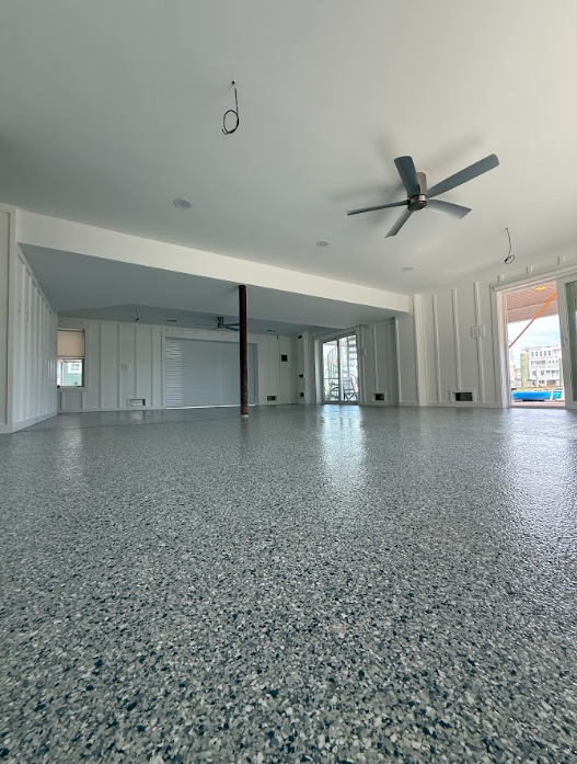 Gray flake epoxy floor in an open living space with a ceiling fan